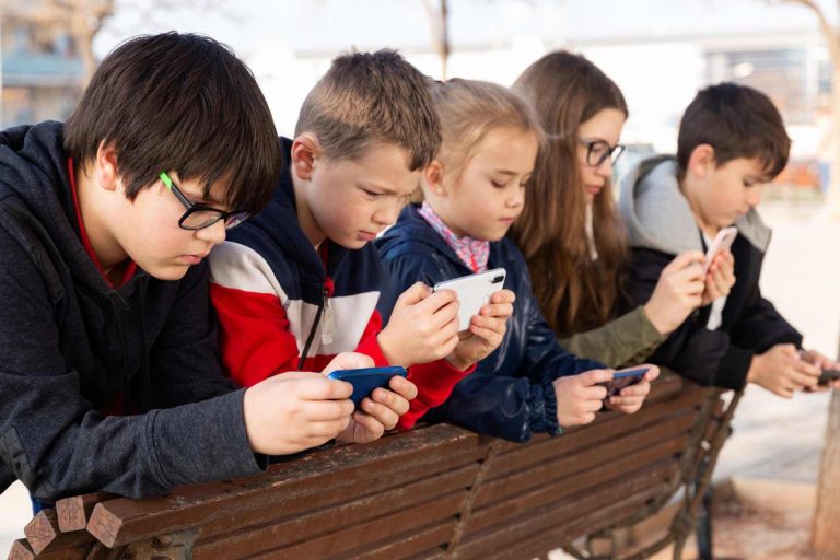 Children looking at their phones, phone & tablet addiction