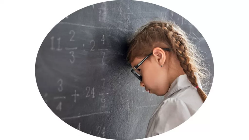 A child struggles with math on black board