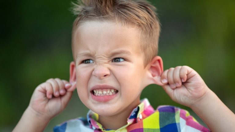 an image of a child pulling his ears to say something