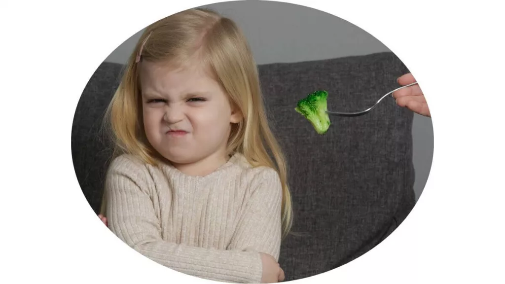 an image of a girl refuses to eat broccoli.